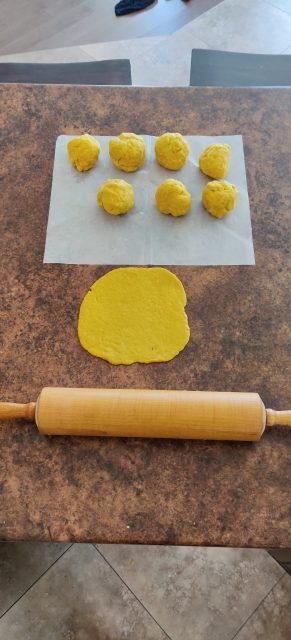 balls of dough being rolled out with a rolling pin