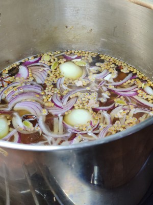 onions, bones and whole spices in a boiling pot of water