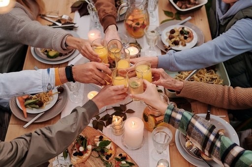 guests do cheers with drinks around a table