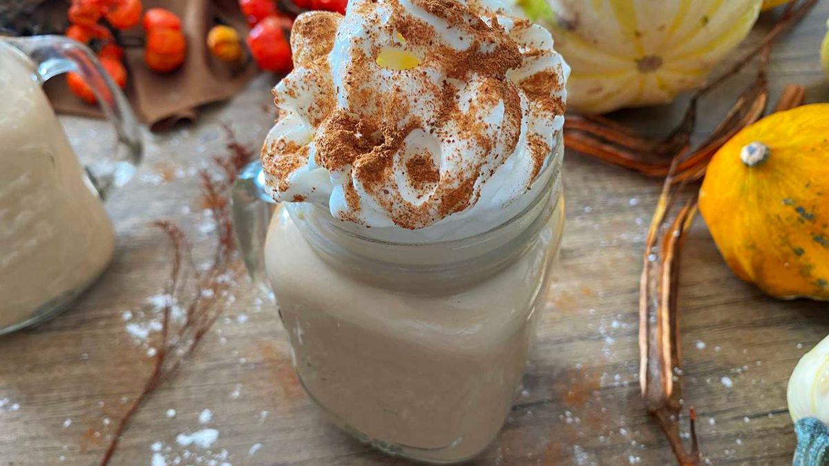 pumpkin spice latte in a mason jar with whipped cream on top.