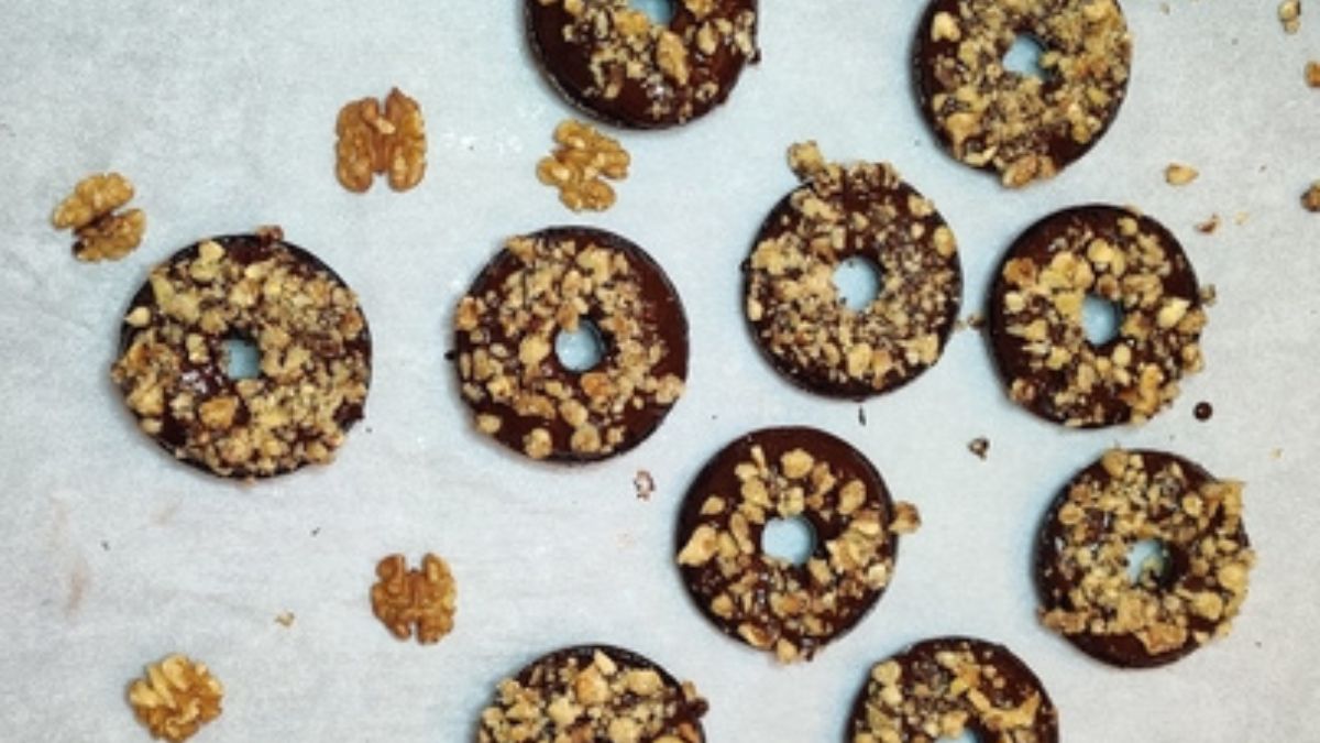 Keto chocolate donuts with glaze and nuts spread on a counter