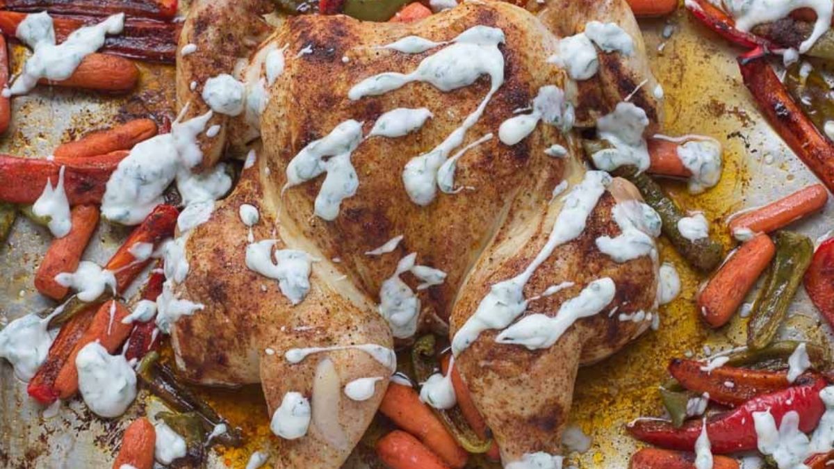 spatchcock chicken with vegetables on a sheet pan.