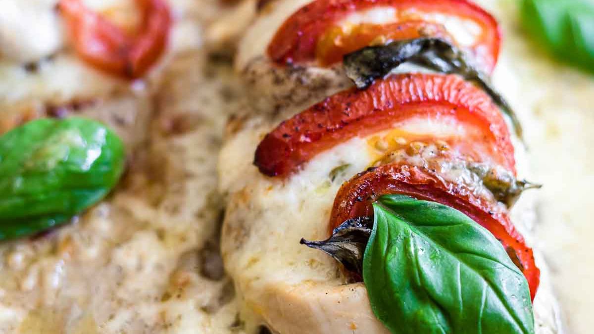 stuffed chicken breast with tomatoes and basil leaves on top