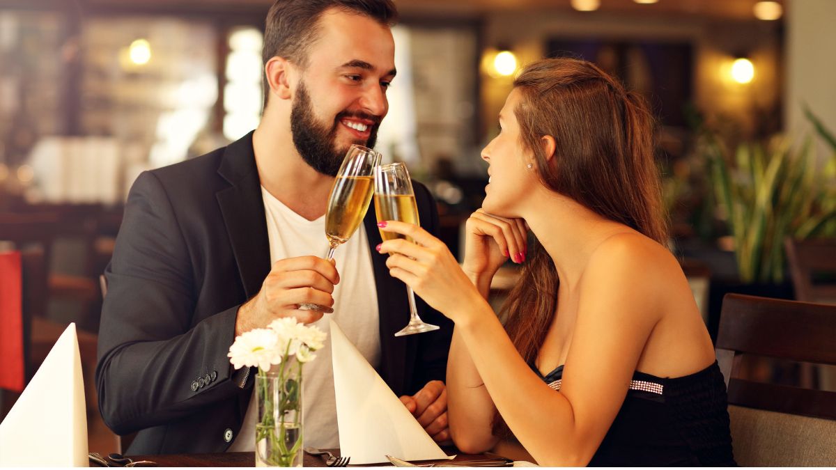 a man and woman on a date holding wine glasses
