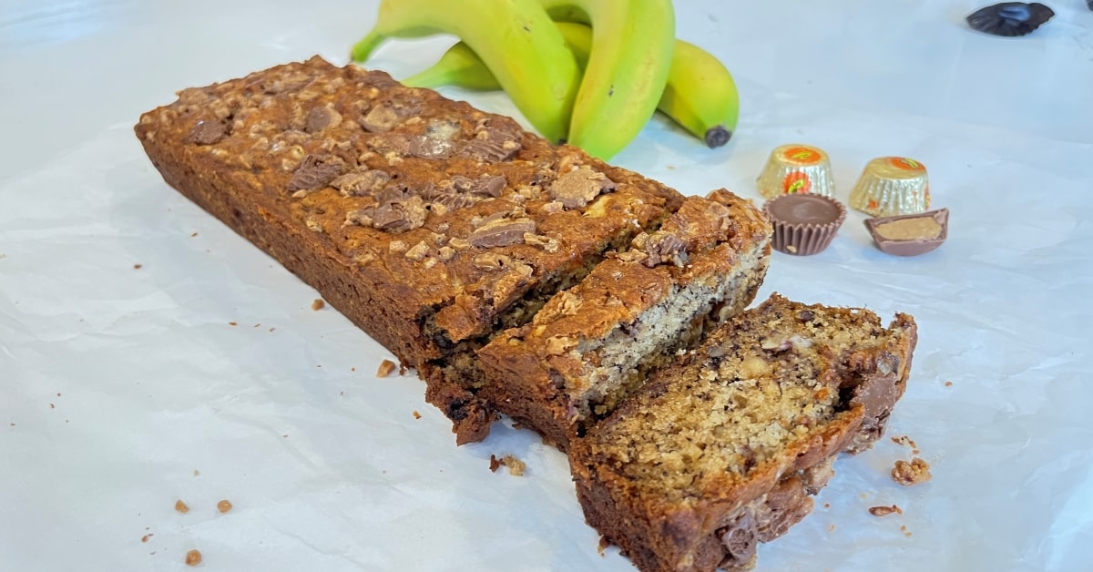 banana bread loaf sliced beside bananas