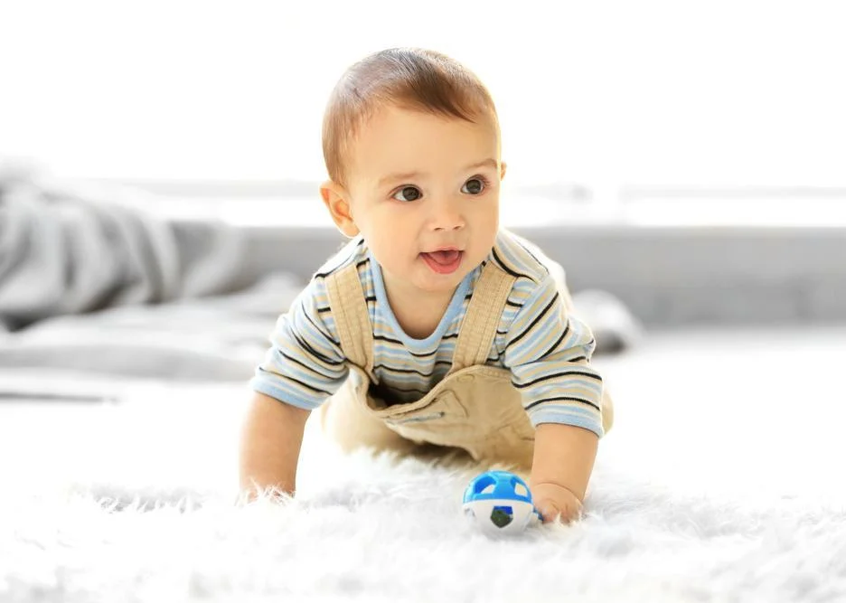 boy crawling on a carpet