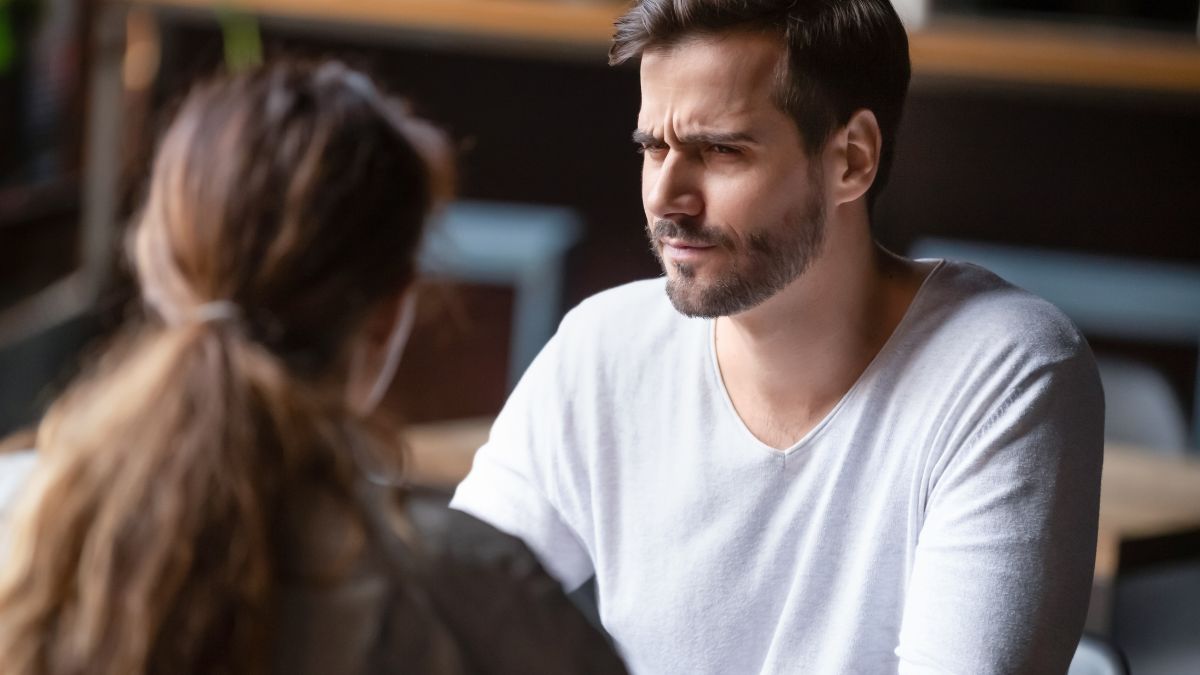 man looking uncomfortable on date with woman