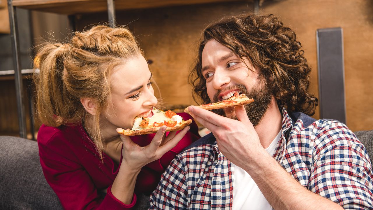 man and woman eating pizza