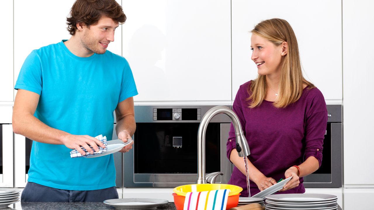man cleaning dishes with woman