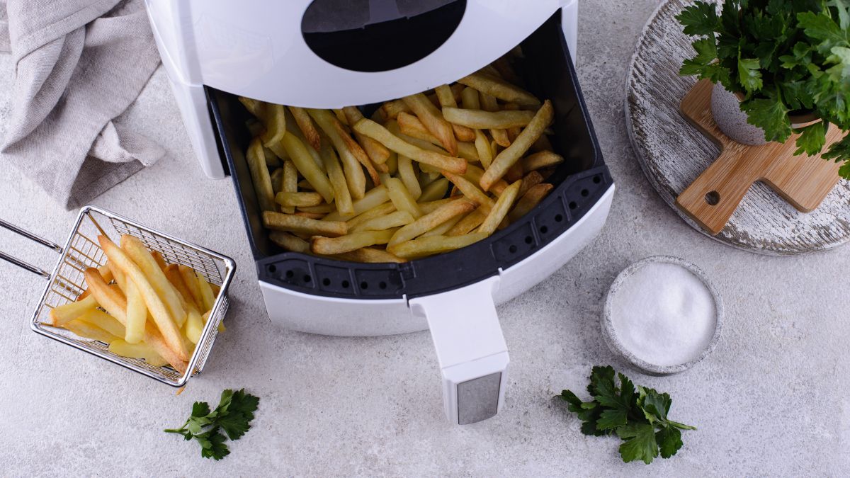 air fryer with french fries in the compartment