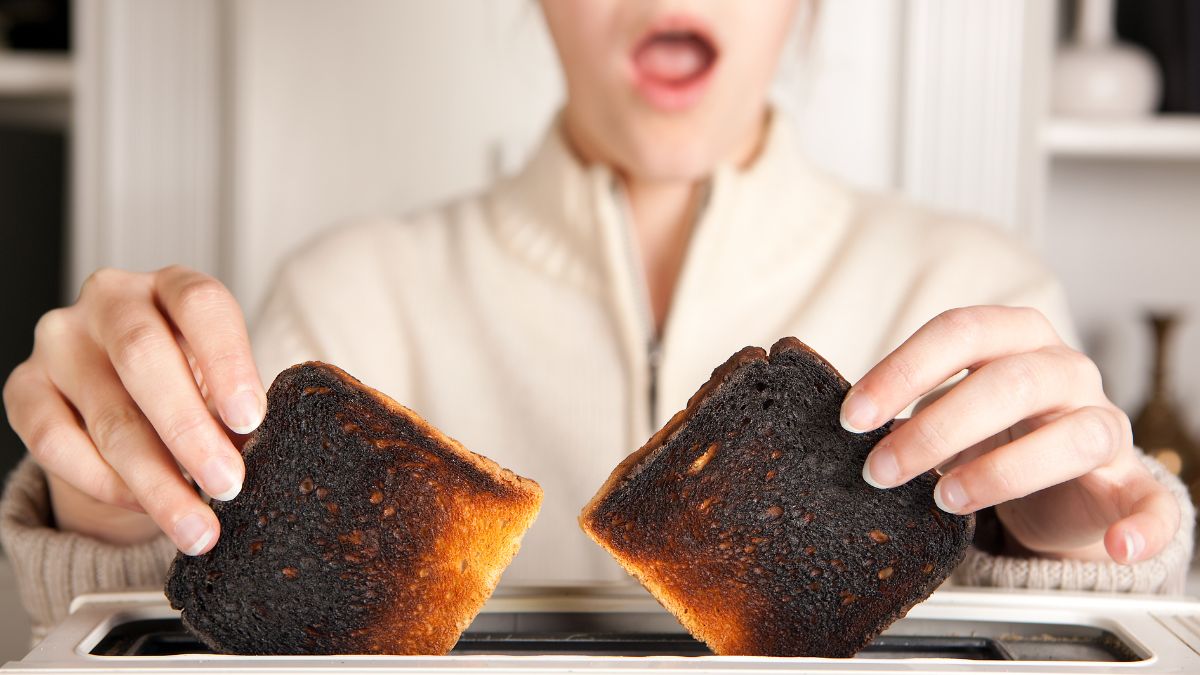 a woman holding two pieces of burnt toast