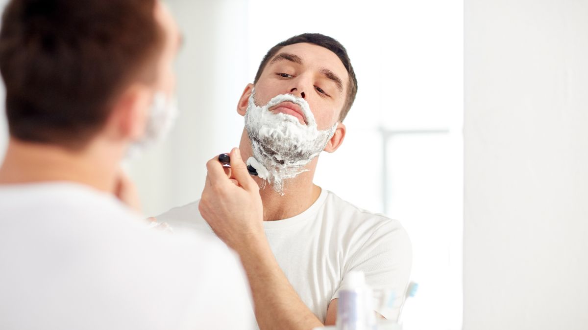 man looking in the mirror shaving