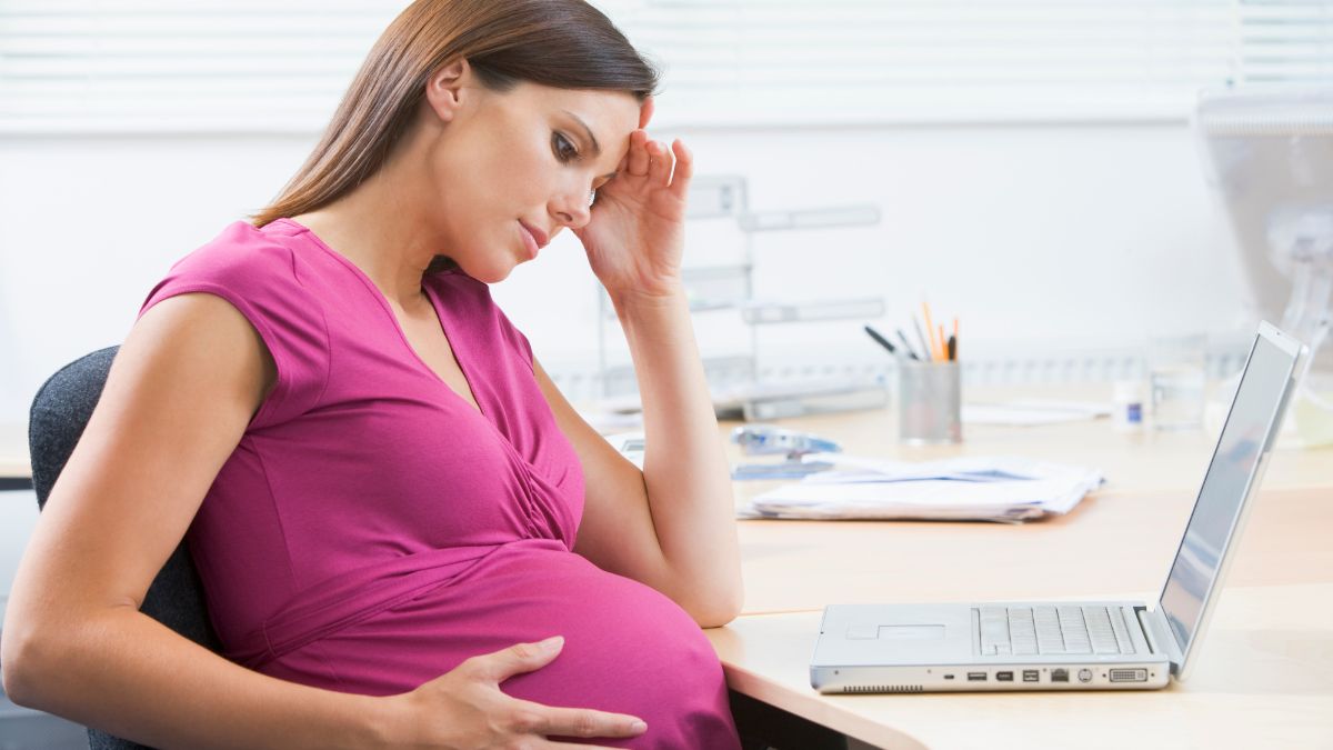 pregnant woman working on laptop looking stressed