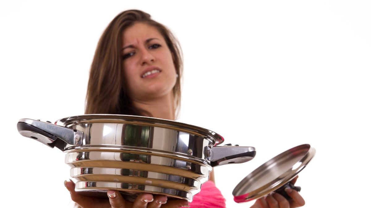 woman hates cooking and is holding a pot with a look of disgust