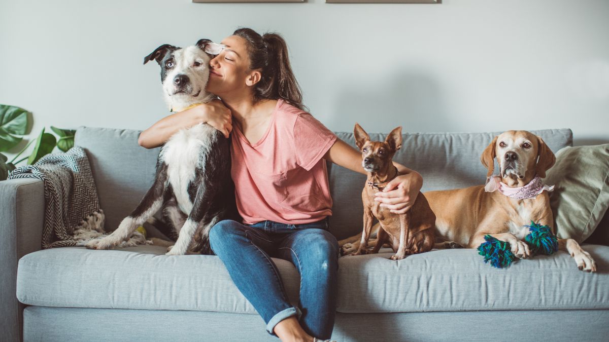 woman hugging her three dogs