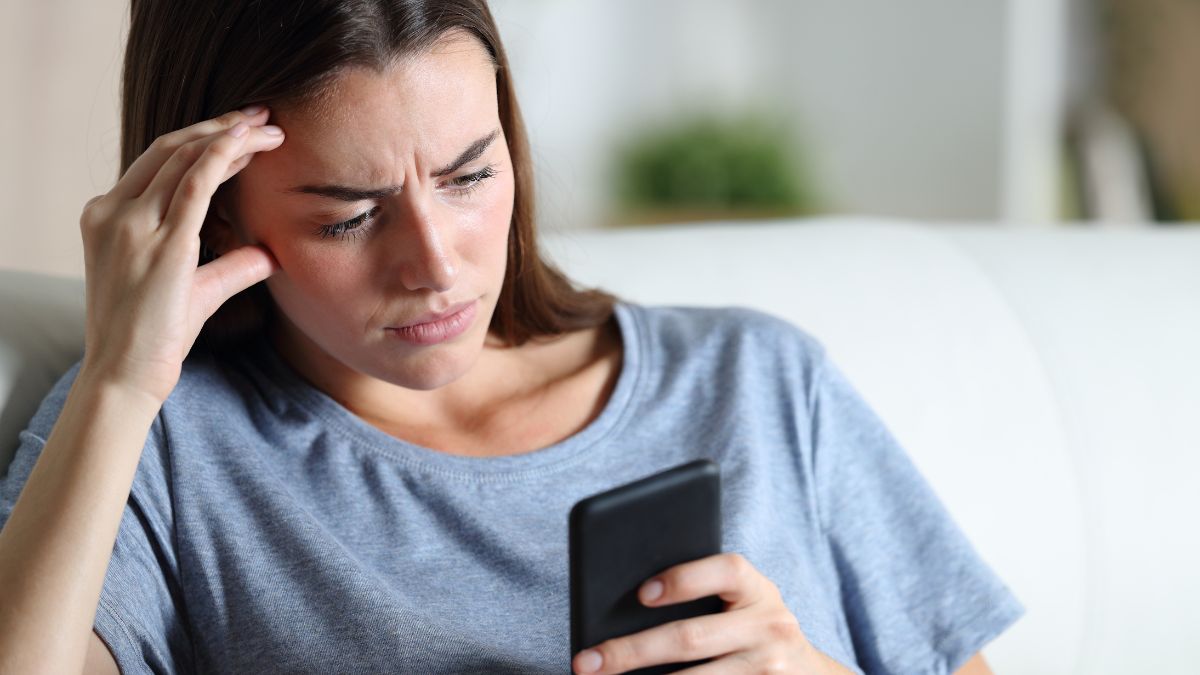 woman looking at her phone stressed