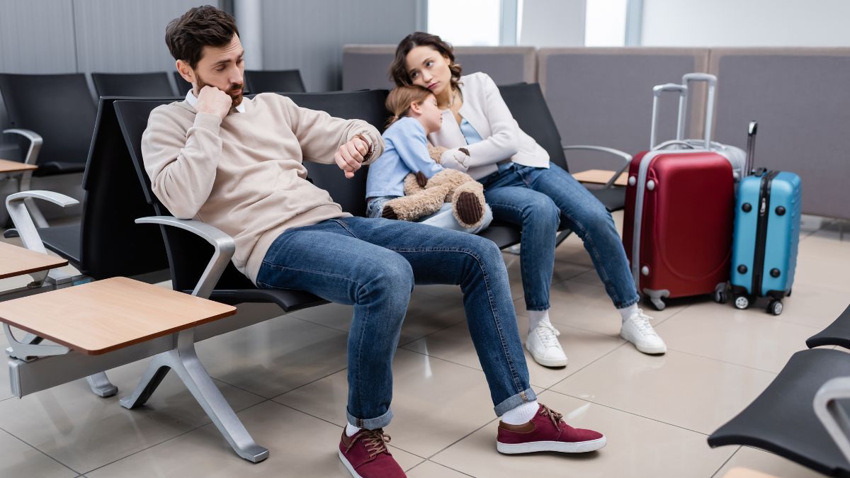 family of husband, wife and daughter are tired from delayed flight. Sitting in airport chairs