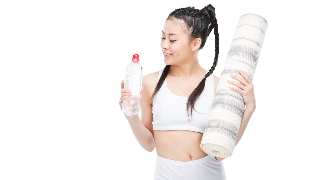 woman holding a water bottle and exercising