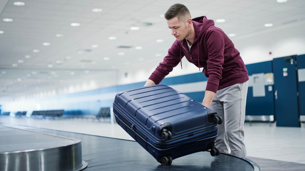 man getting carryon from airport