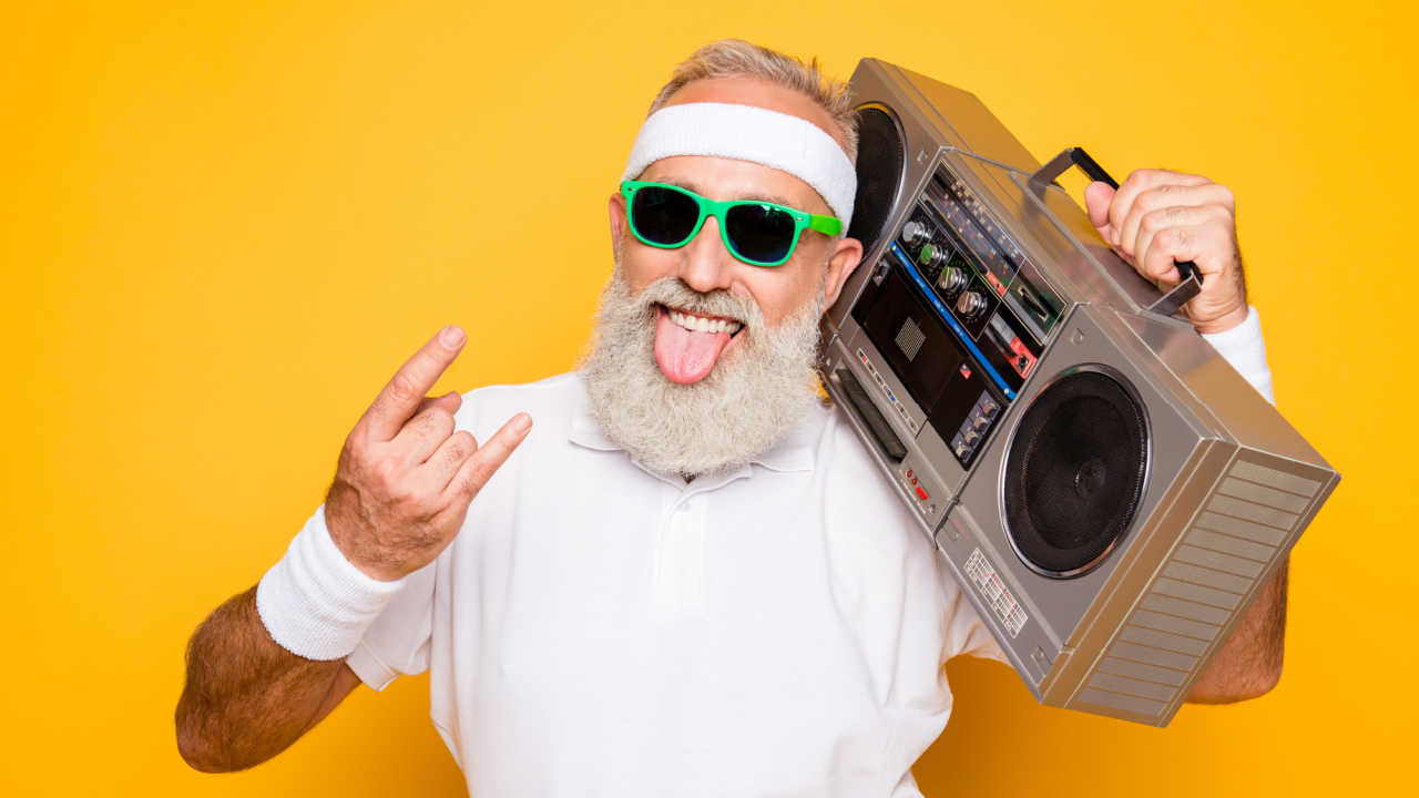 man holding boom box, has tongue out and hand making rock and roll sign