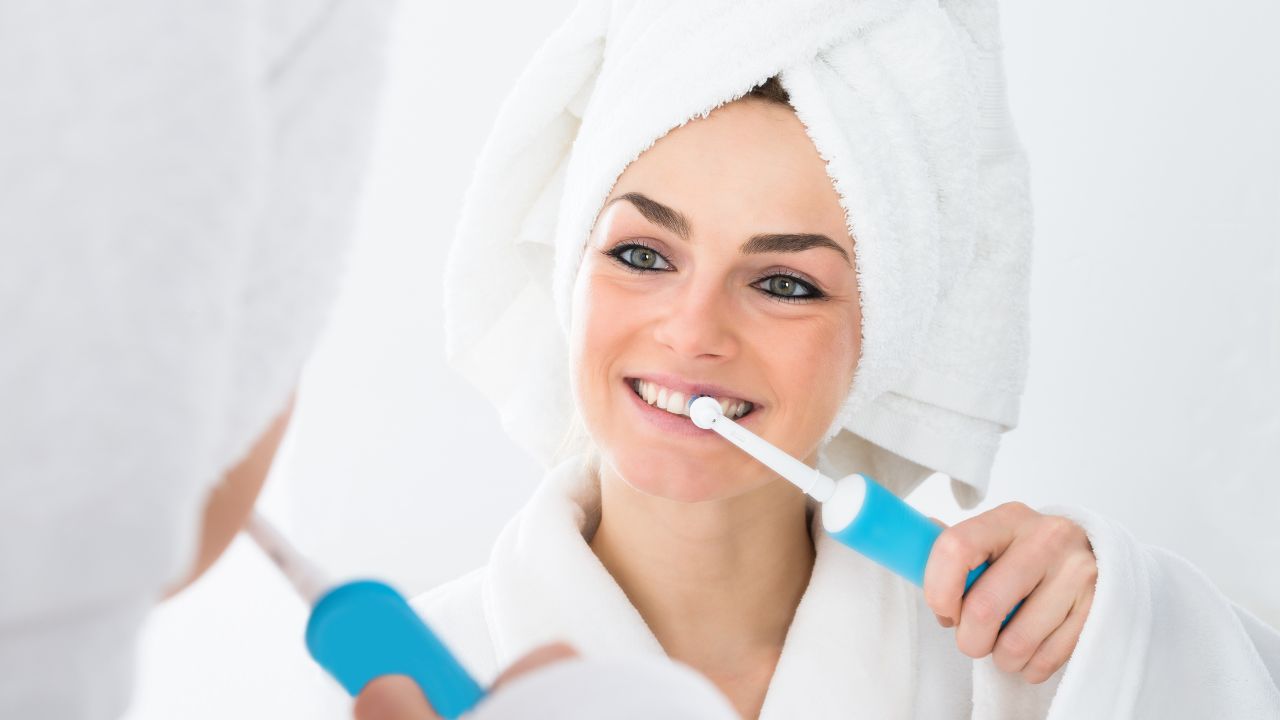 woman using an electric toothbrush
