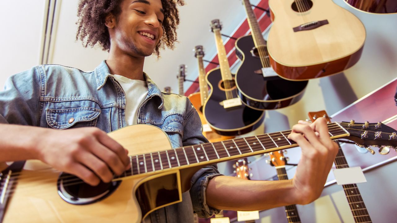 boy playing a guitar in a store
