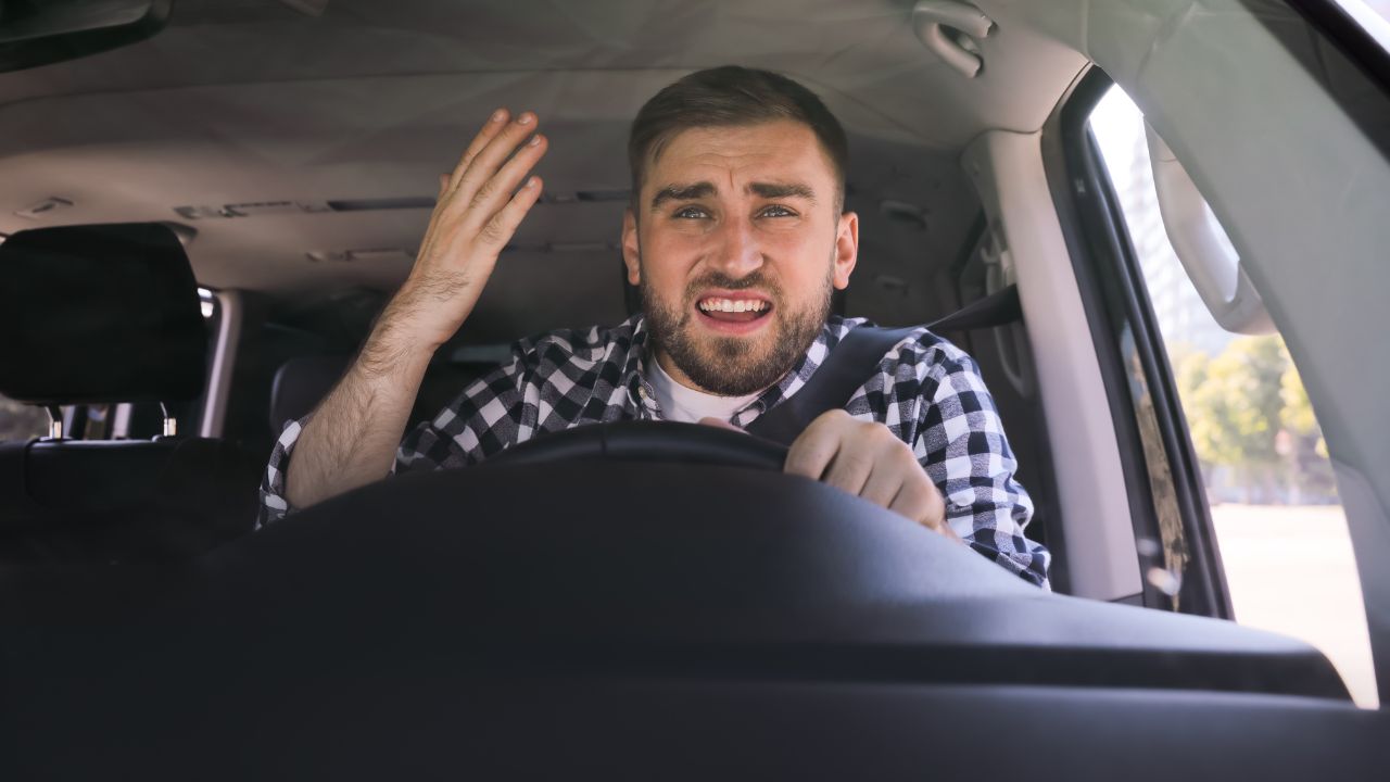 man in driver's seat looking frustrated