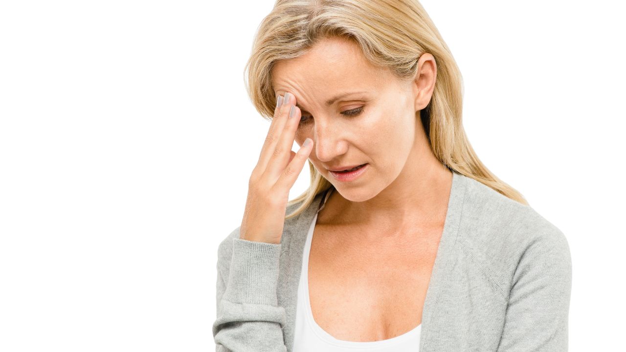 woman holding head looking stressed