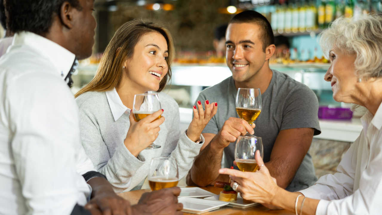 people sitting together having drinks at a bar