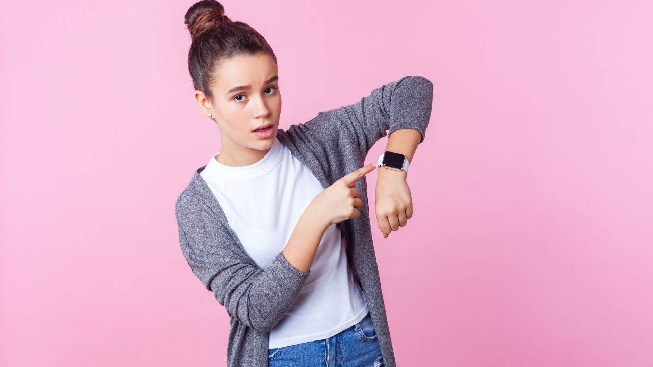 teenage girl looking at watch and acting impatient
