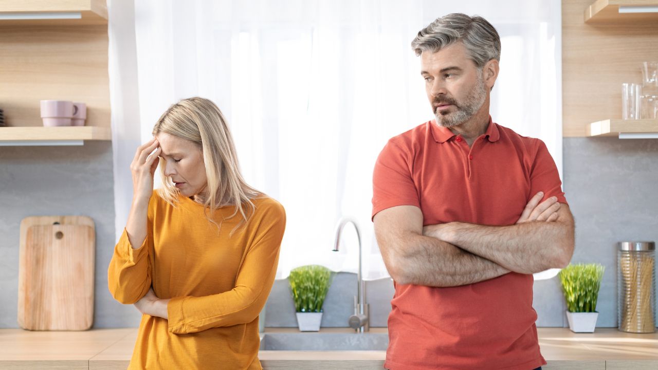woman with head down looking frustrated with man