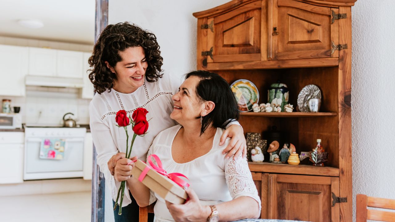 woman giving gift and flowers to mother