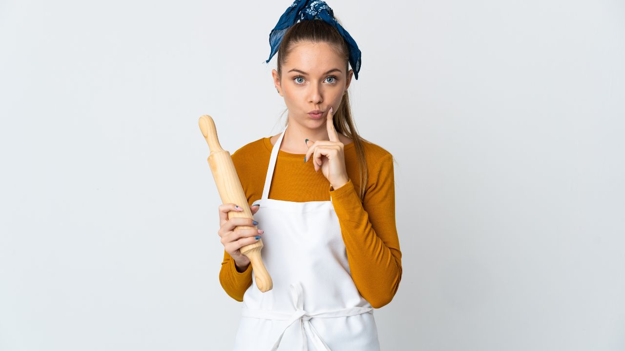 woman baker holding a rolling pin and thinking