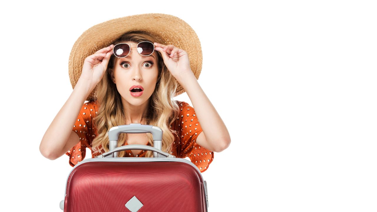 woman traveler with suitcase and sunglasses looking surprised