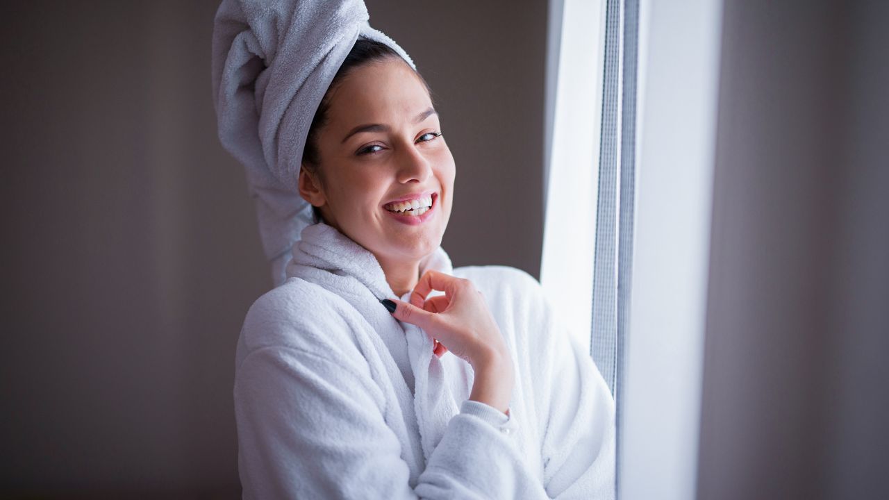 woman wearing a robe and towel on head after a shower