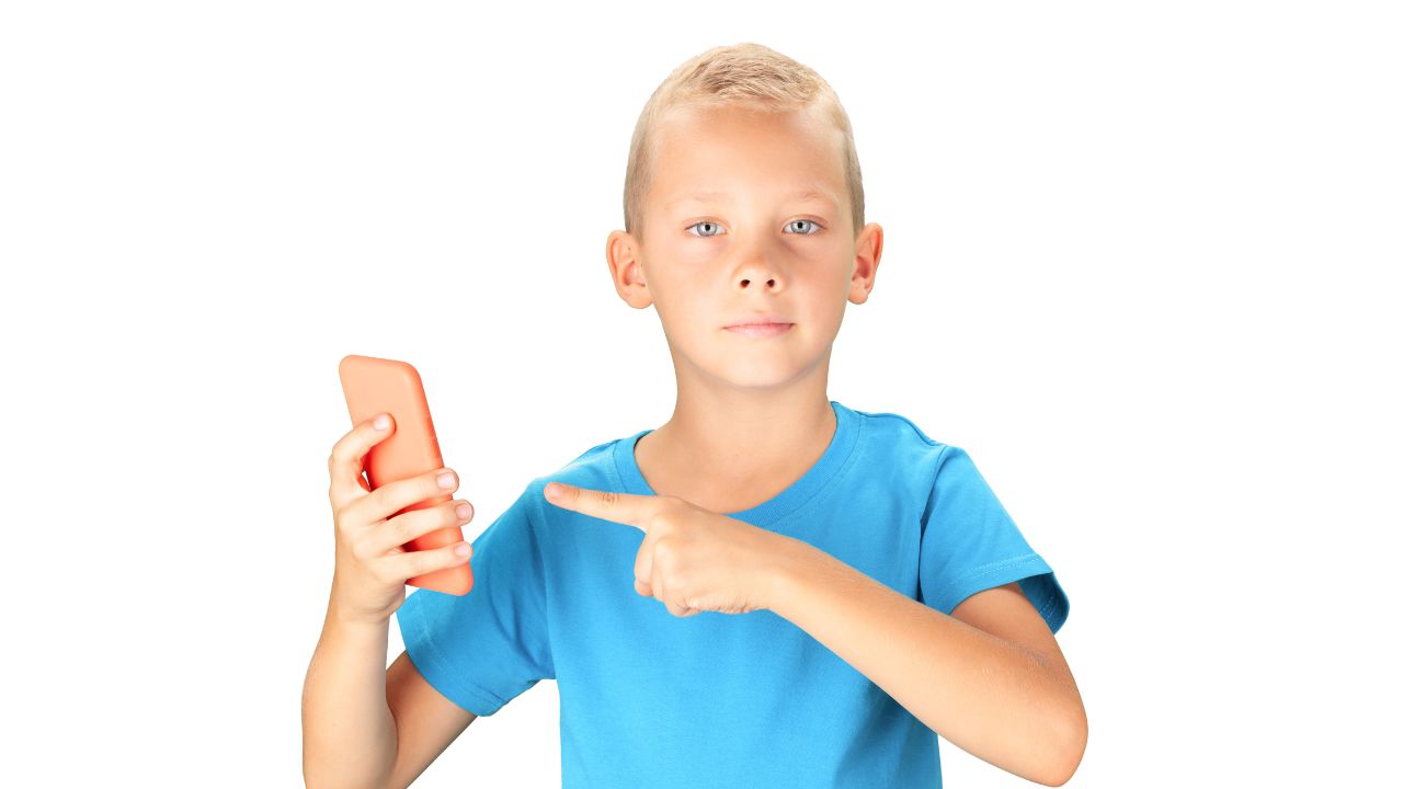 boy holding cell phone and pointing at it