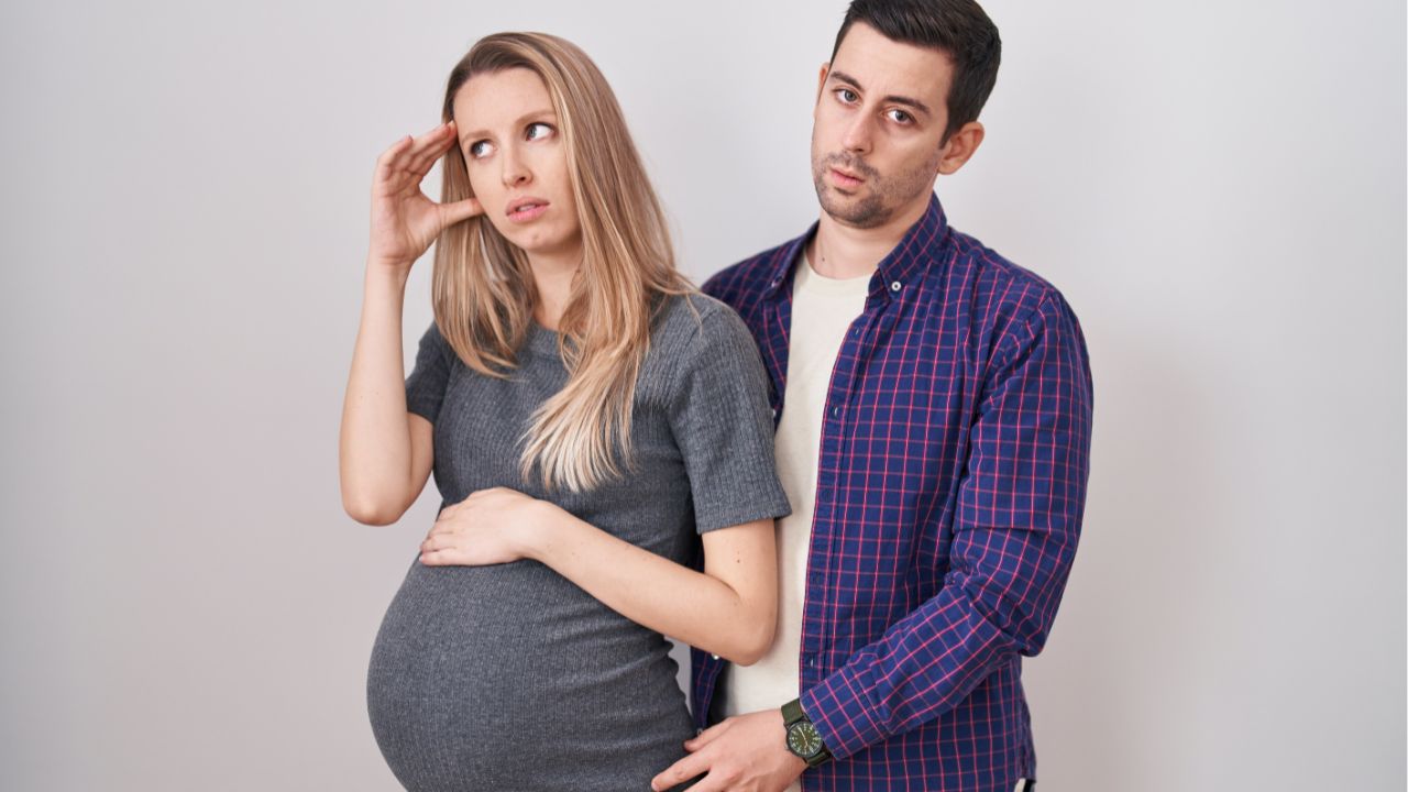 man with pregnant woman looking stressed