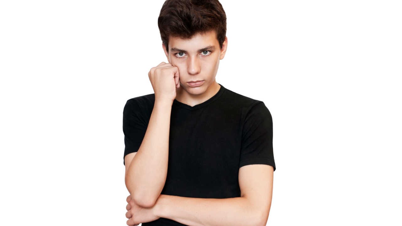 teenage boy with hand on face looking sad or upset