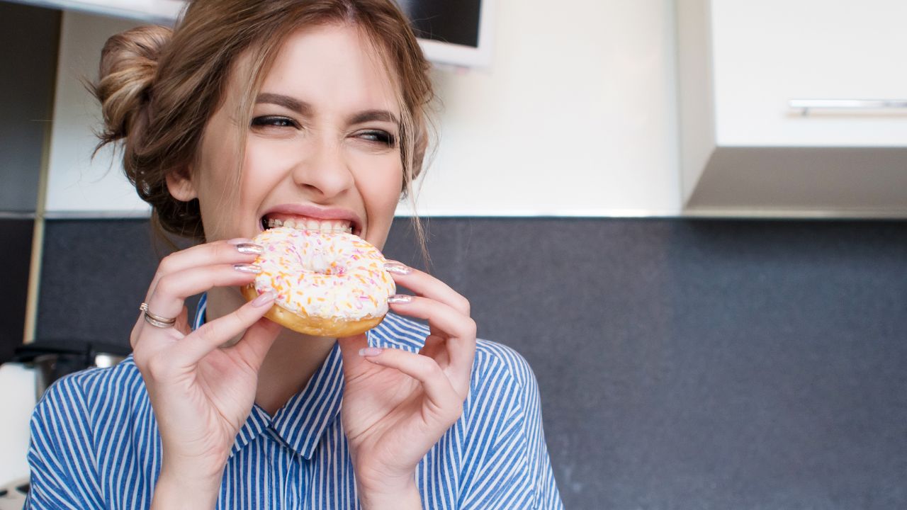woman eating a donut for dessert