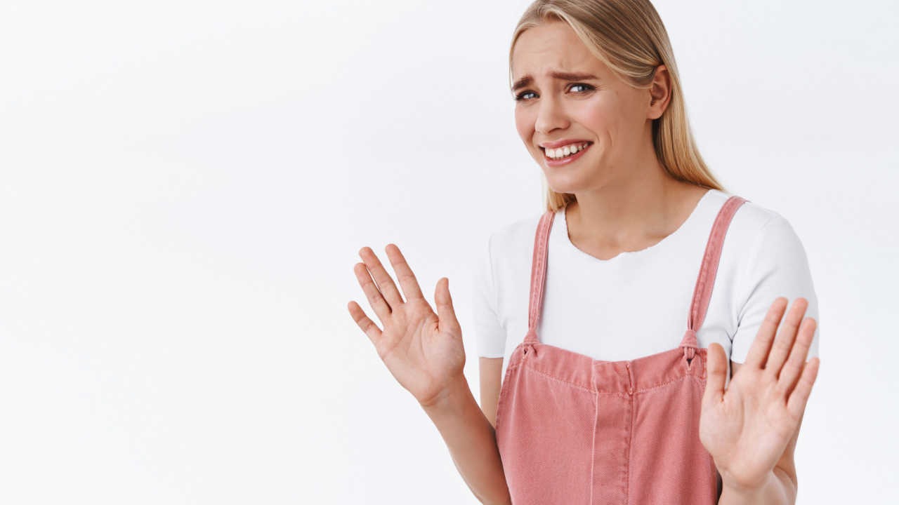 woman with hands up feeling bad, singled out