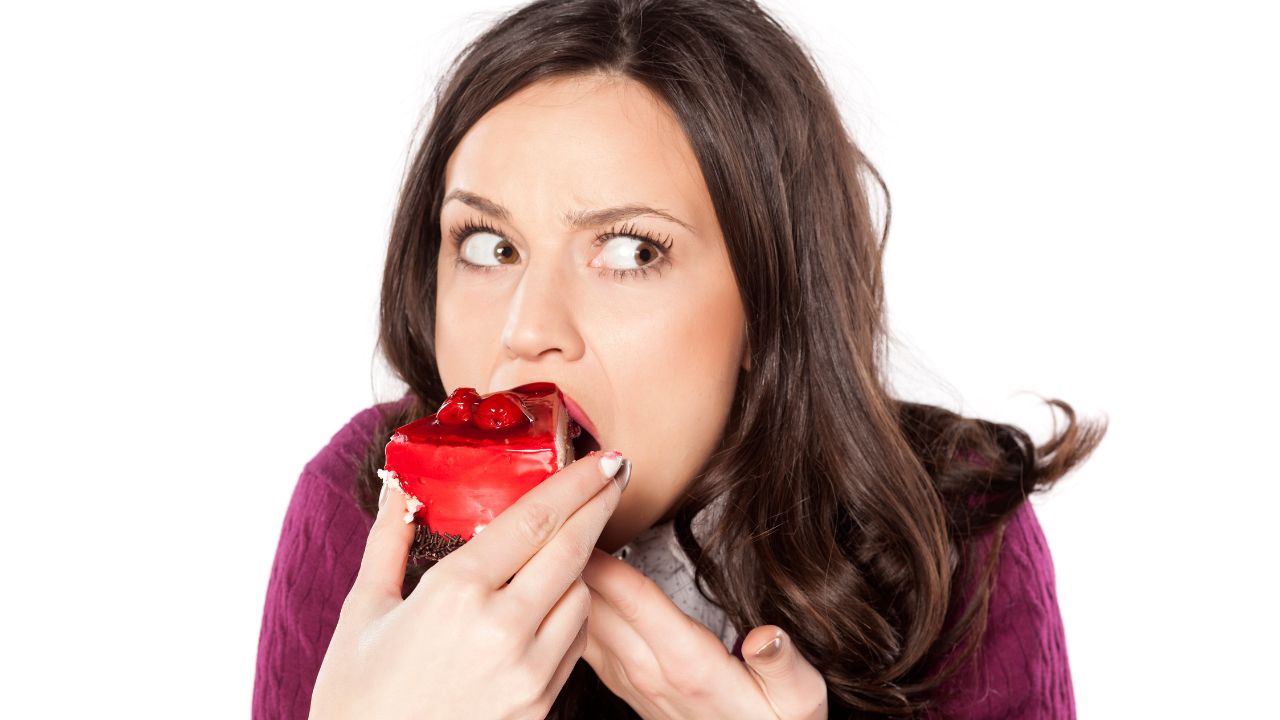 woman eating a piece of cake secretly