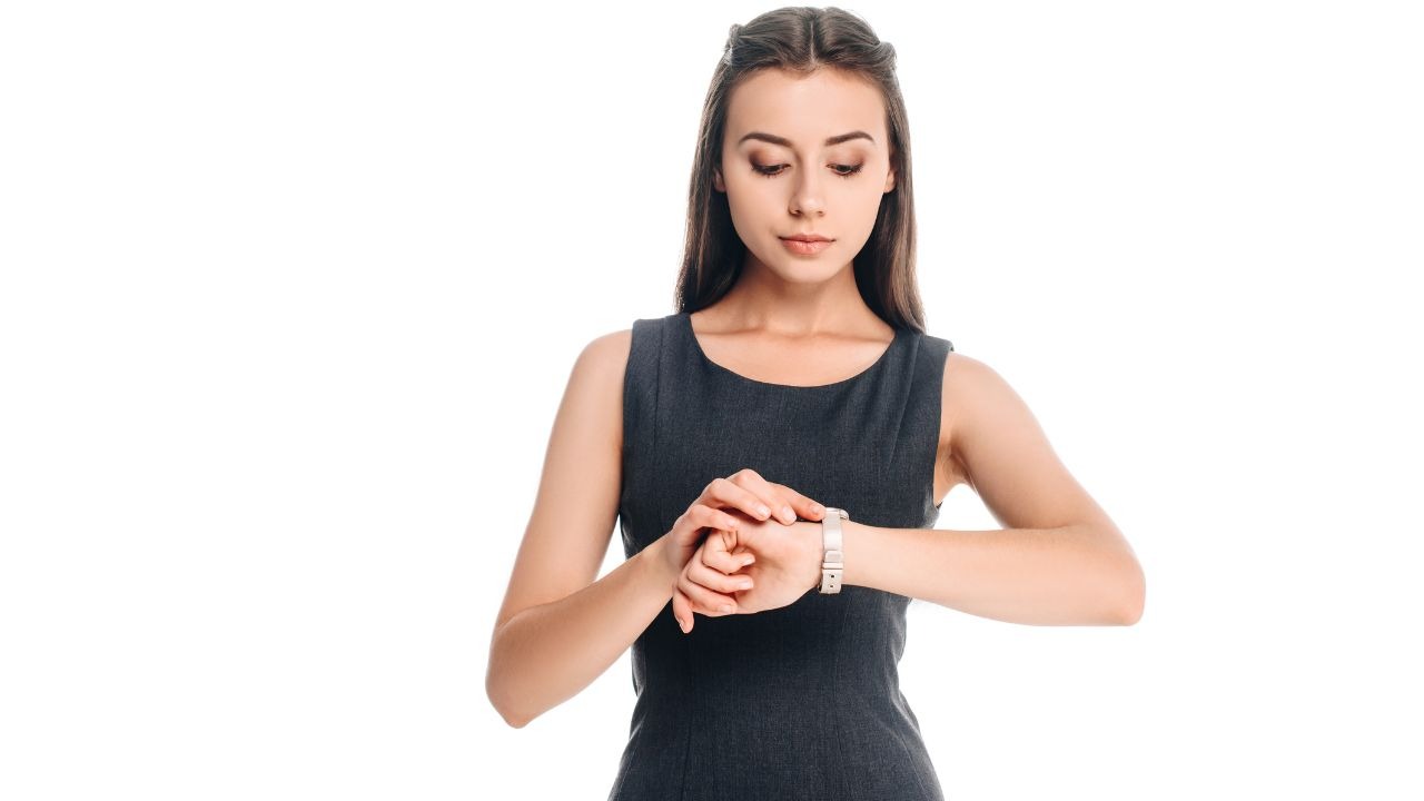 woman wearing a black dress and looking at her watch