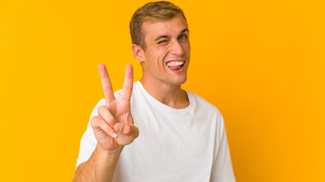 man giving peace sign, winking and sticking tongue out