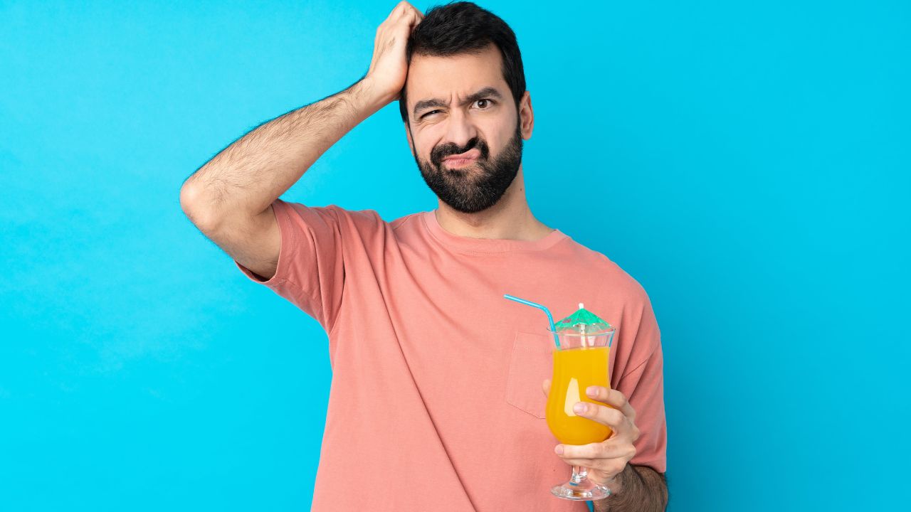 man looking confused and holding a cocktail