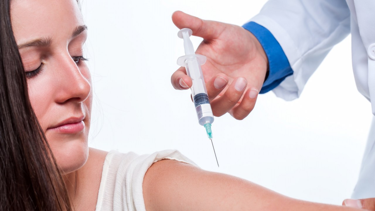 Woman getting vaccine or needle