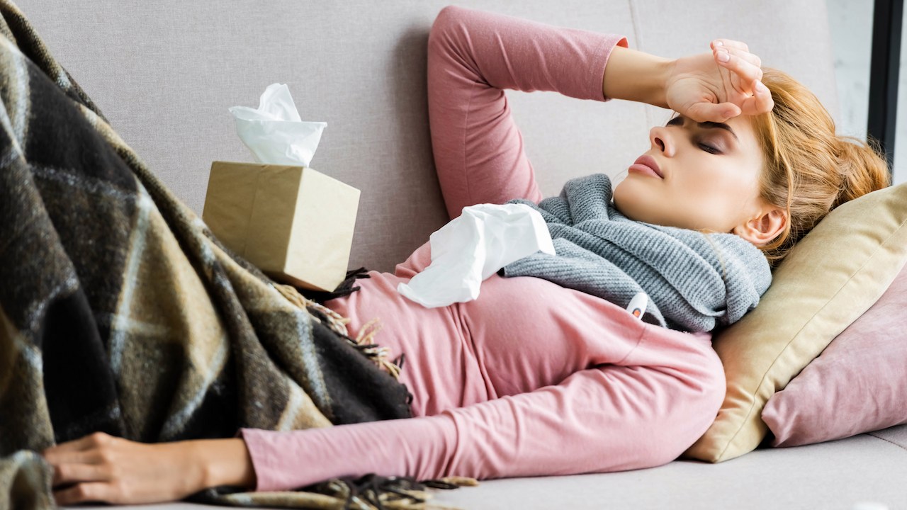 Woman lying on couch, sick with flu