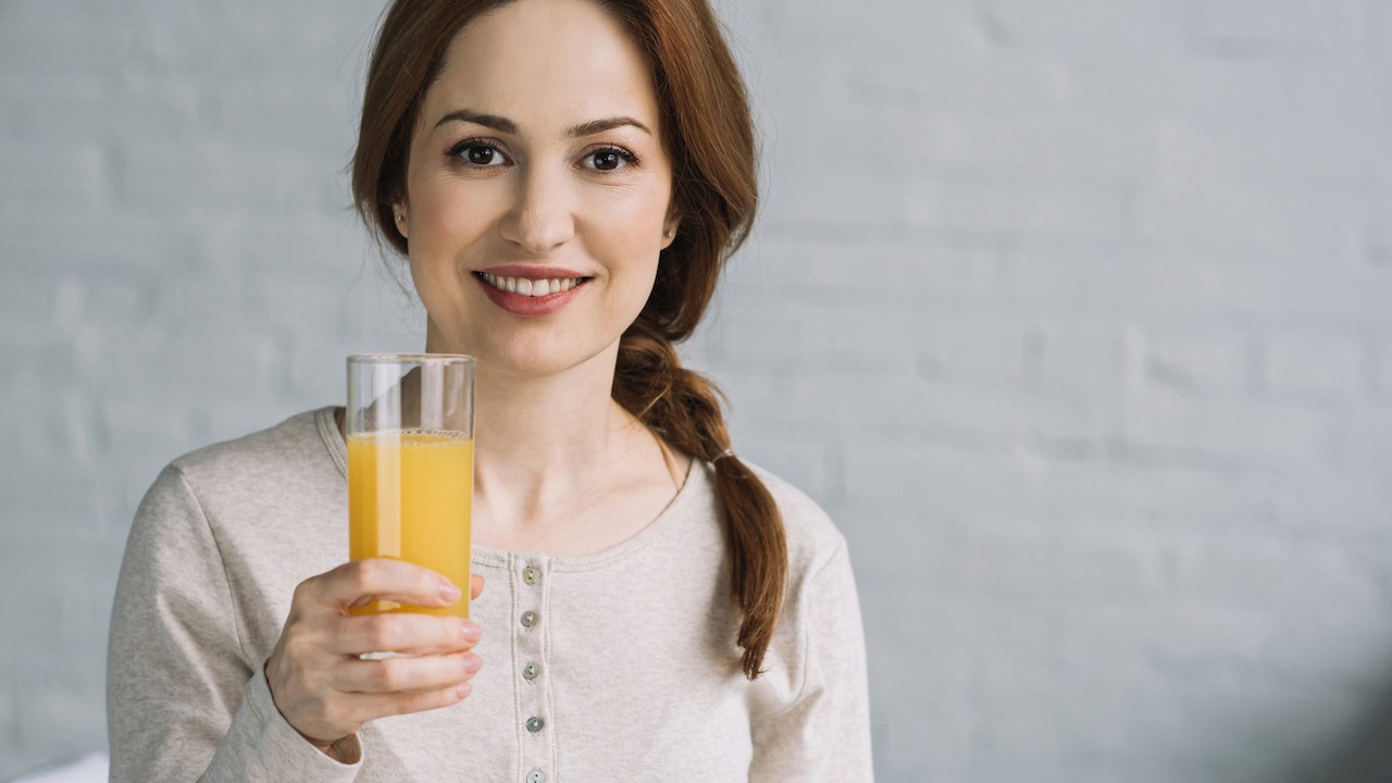 Woman holding glass of juice