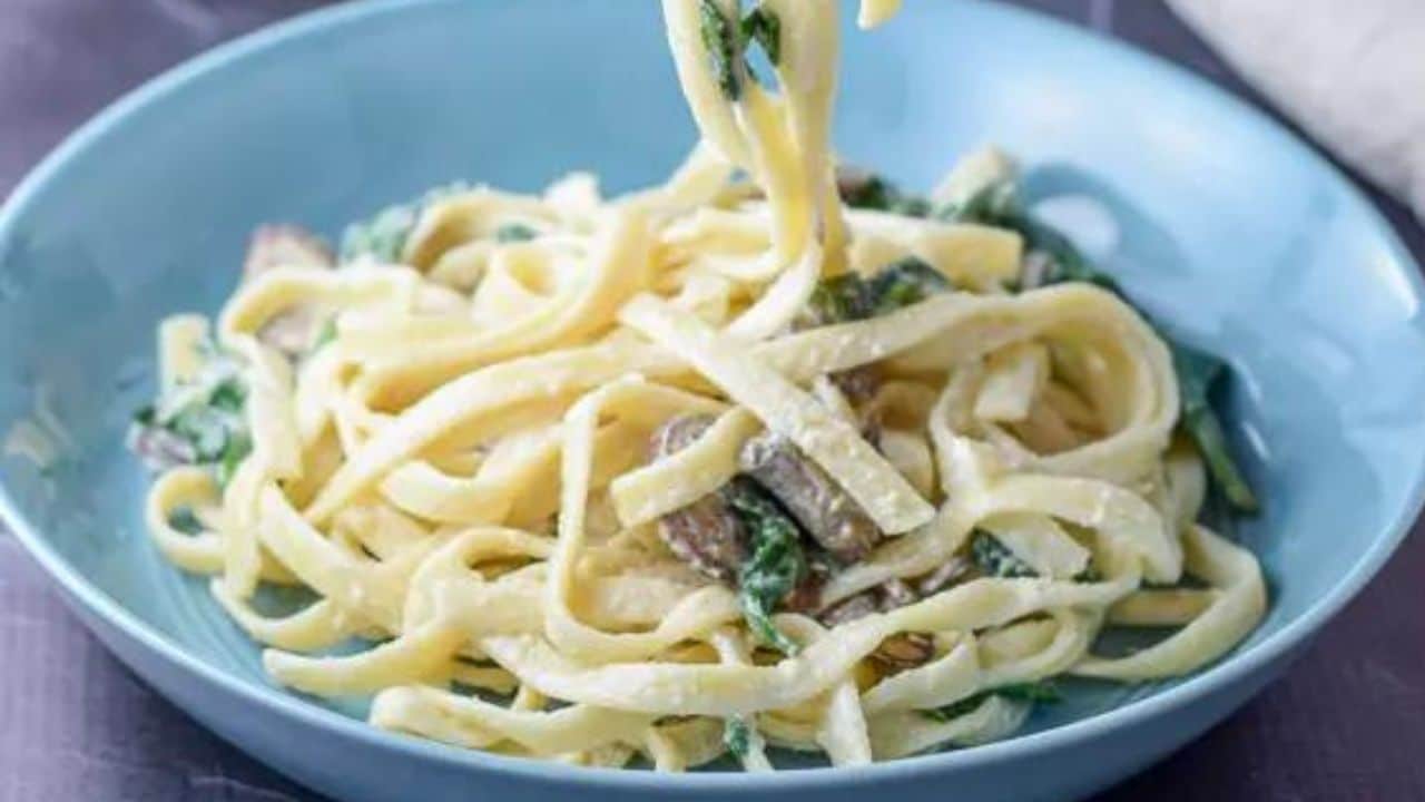 spinach and mushroom fettucini alfredo in a bowl