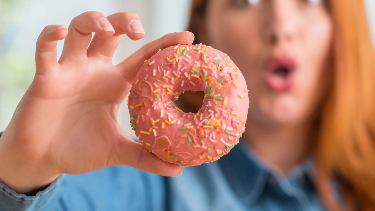 woman holding a donut